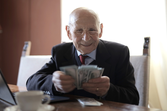 An older gentleman sorting his cash to self fund his care home fees